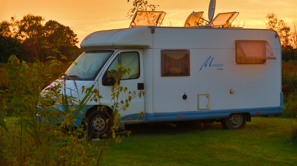 Wohnmobil auf Wiese im Sonnenuntergang